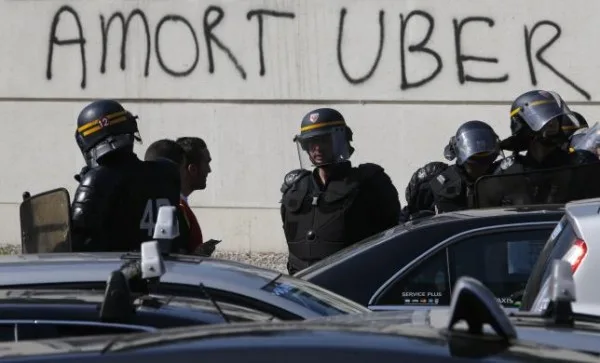 French riot police secure the Porte Maillot during a demonstration by French taxi drivers, who are on strike, to block the traffic on the Paris ring road during a national protest against car-sharing service Uber, in Paris