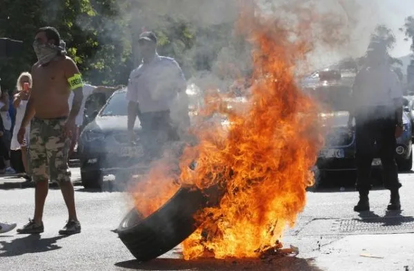Taxi drivers on strike burn tyres during a national protest against car-sharing service Uber in Marseille