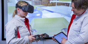 Together with a trainer, an Audi Packing Logistics employee practices the proper techniques for packing brake discs and other large parts for shipping overseas. Thanks to a pair of virtual reality glasses, she can train in a realistic and true-to-life simulation of her work station in Hall L of the Ingolstadt Logistics Center.