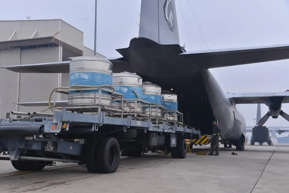 Four tanks of salt and water mixture are loaded into RMAF's Lockheed C-130 Hercules transporter.