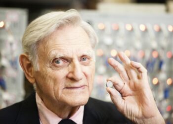 John Goodenough holding battery